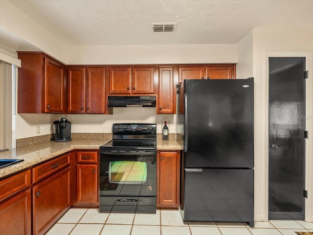 kitchen featuring light stone countertops, light tile patterned flooring, black appliances, and a textured ceiling