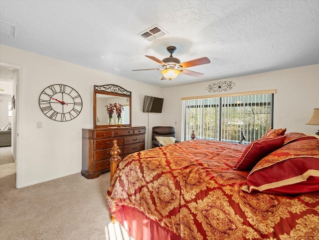 bedroom with a textured ceiling, ceiling fan, access to exterior, and light carpet