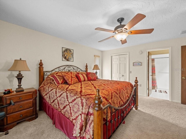 bedroom with ensuite bath, ceiling fan, a closet, and light carpet