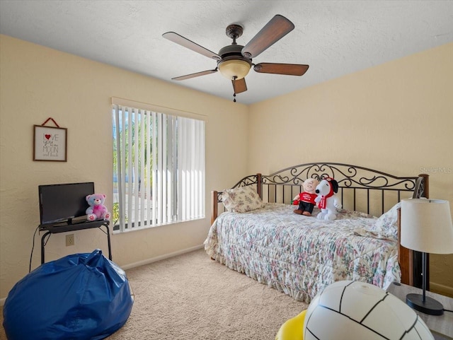 bedroom featuring ceiling fan, carpet floors, and a textured ceiling