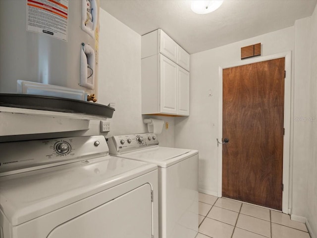 washroom featuring cabinets, independent washer and dryer, and light tile patterned floors