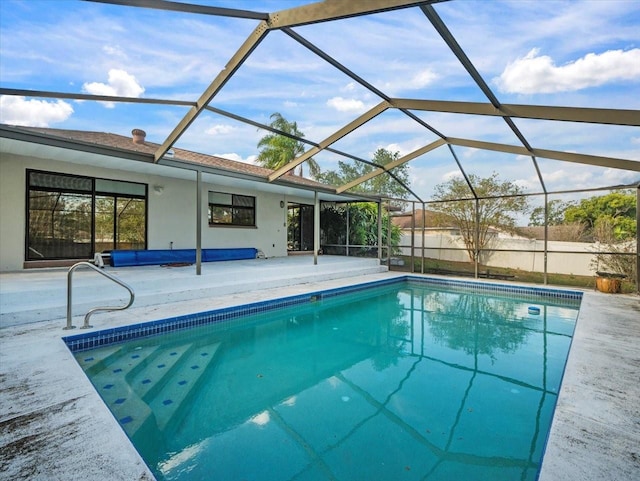 view of pool with glass enclosure and a patio area