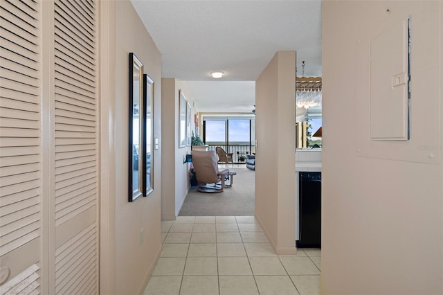 4620 Bay Blvd Unit 1148, Port Richey, FL 34668 - hallway featuring light tile patterned flooring, a textured ceiling, light colored carpet, baseboards, and electric panel