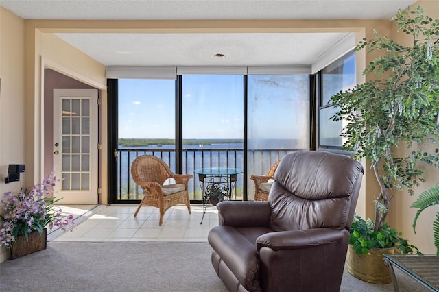 sunroom featuring a water view