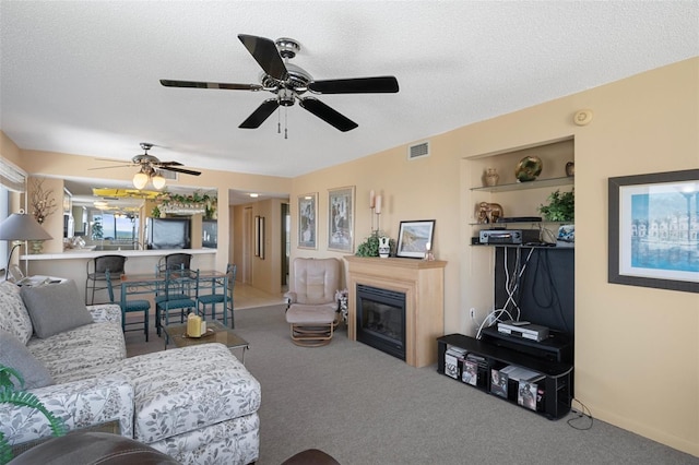 carpeted living room featuring ceiling fan and a textured ceiling