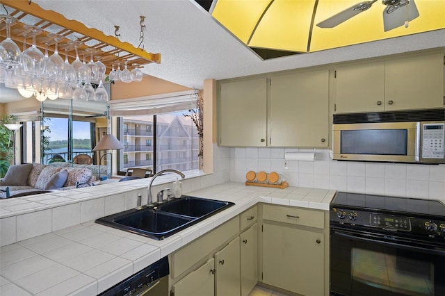 kitchen featuring tile countertops, backsplash, stainless steel appliances, and sink