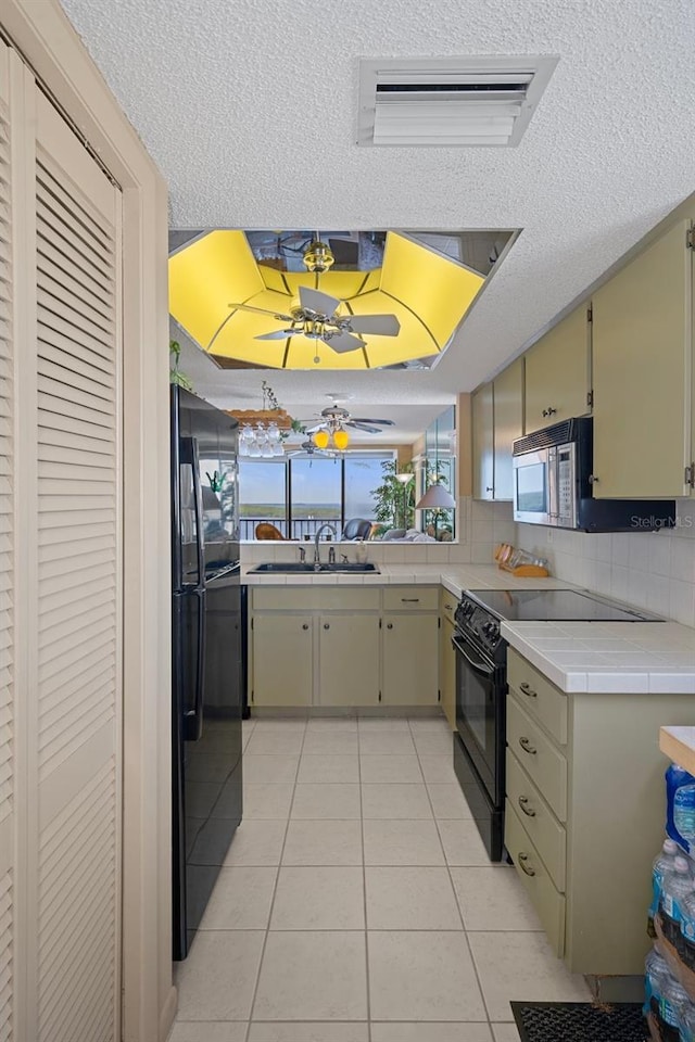 4620 Bay Blvd Unit 1148, Port Richey, FL 34668 - kitchen with black appliances, light tile patterned flooring, a sink, a textured ceiling, and decorative backsplash