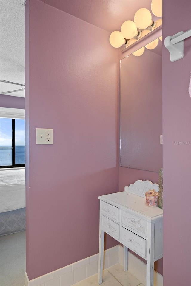 bathroom featuring a textured ceiling and a water view