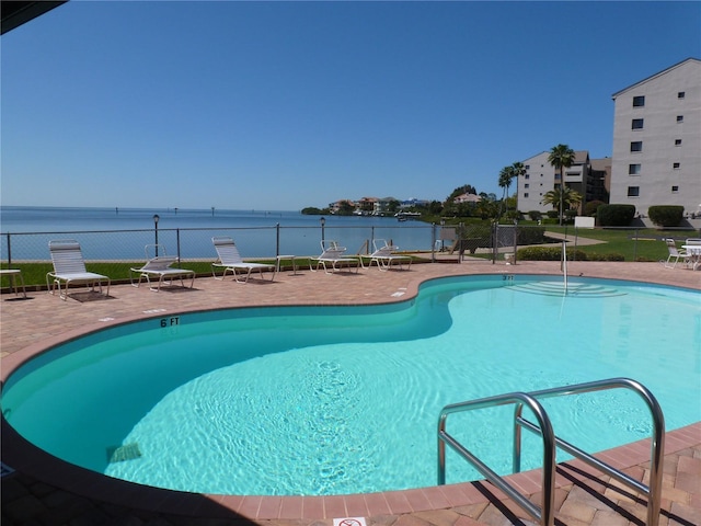 view of pool with a water view and a patio