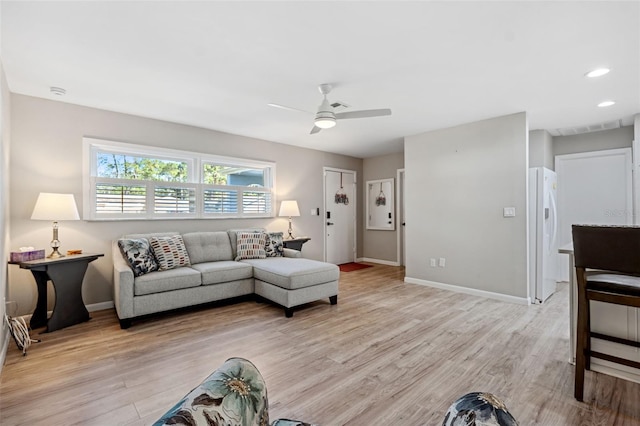 living room featuring light hardwood / wood-style flooring and ceiling fan