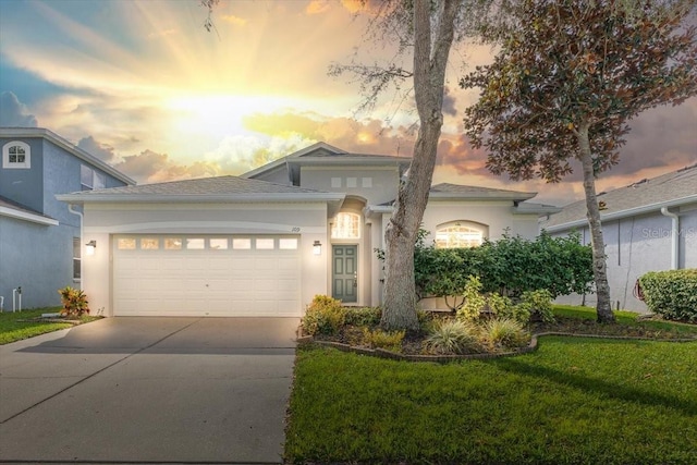 view of front of home with a garage and a yard