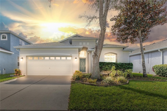 view of front of house featuring a garage and a lawn