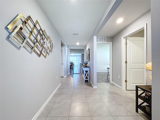 hall with light tile patterned floors and a textured ceiling