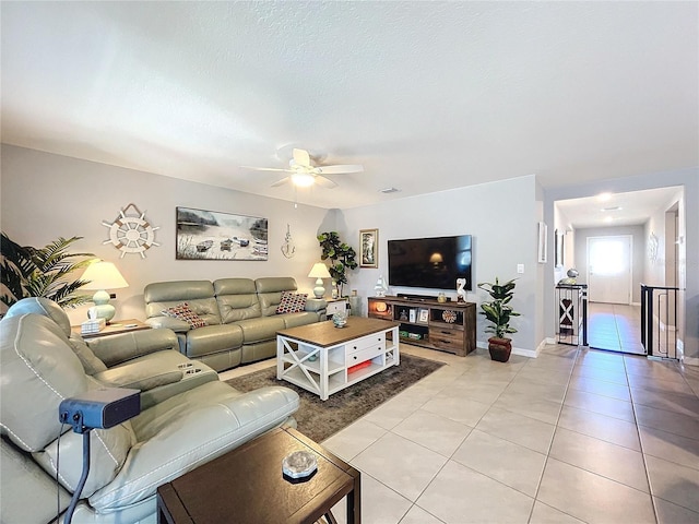 tiled living room featuring ceiling fan and a textured ceiling