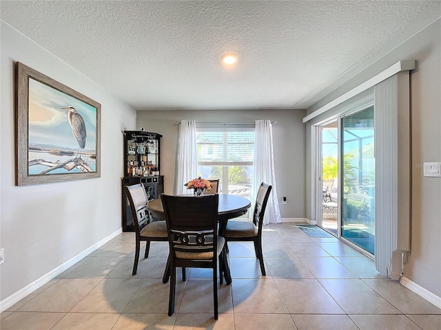 tiled dining area with a textured ceiling