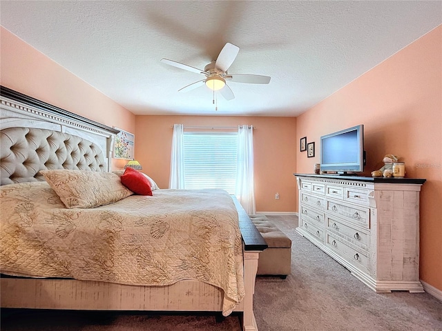 bedroom with ceiling fan, carpet floors, and a textured ceiling