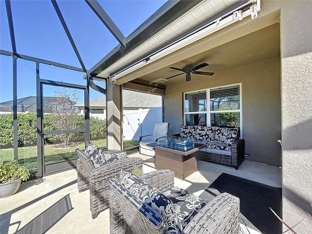 view of patio featuring glass enclosure, an outdoor living space, and ceiling fan