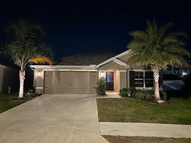 single story home featuring a lawn and a garage