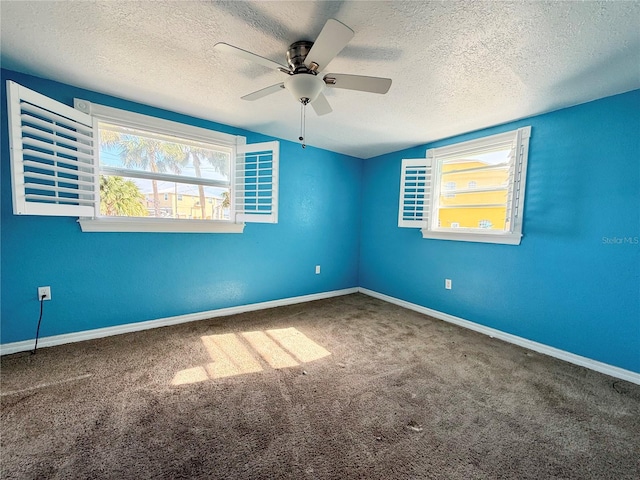 carpeted empty room with vaulted ceiling, ceiling fan, and a textured ceiling