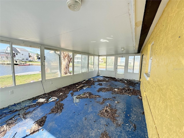 unfurnished sunroom with a water view