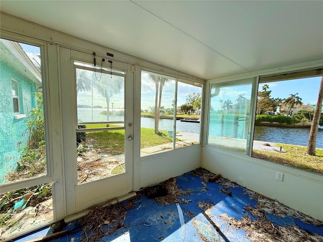 unfurnished sunroom with a wealth of natural light and a water view