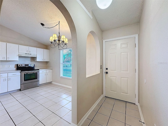 kitchen with a textured ceiling, light tile patterned floors, electric range, white cabinets, and hanging light fixtures