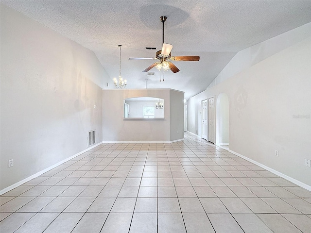 unfurnished living room with a textured ceiling, ceiling fan with notable chandelier, vaulted ceiling, and light tile patterned floors