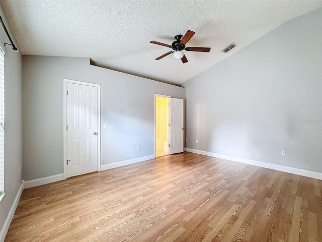 unfurnished bedroom with a textured ceiling, light hardwood / wood-style flooring, vaulted ceiling, and ceiling fan