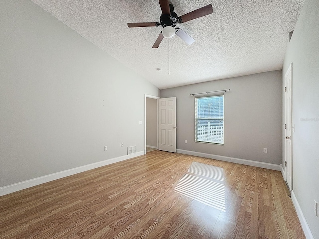 unfurnished room with ceiling fan, light wood-type flooring, and a textured ceiling