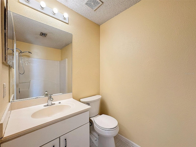 bathroom with vanity, a textured ceiling, toilet, and walk in shower