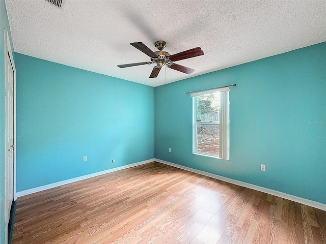 spare room featuring ceiling fan, a textured ceiling, and light hardwood / wood-style flooring