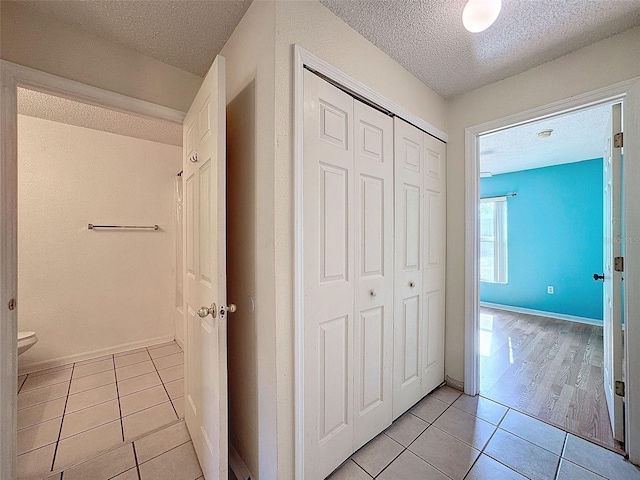 hall featuring light hardwood / wood-style floors and a textured ceiling