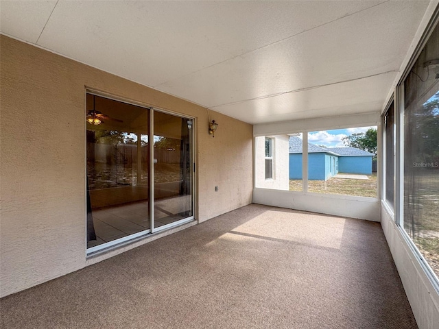 unfurnished sunroom with ceiling fan