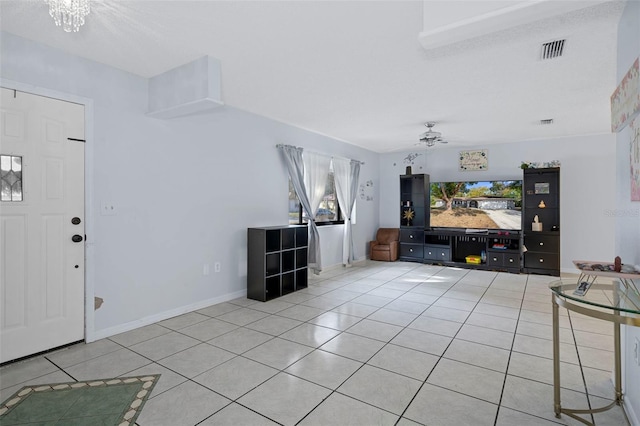 unfurnished living room with tile patterned flooring, plenty of natural light, and ceiling fan with notable chandelier