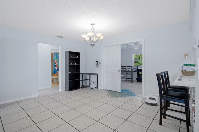 tiled dining room featuring a textured ceiling and ceiling fan with notable chandelier