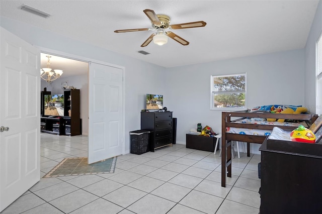 tiled bedroom featuring ceiling fan with notable chandelier