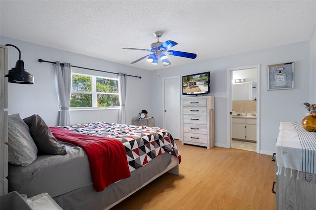 bedroom featuring sink, ensuite bath, ceiling fan, a textured ceiling, and light hardwood / wood-style floors