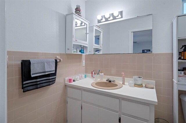 bathroom with vanity and tile walls