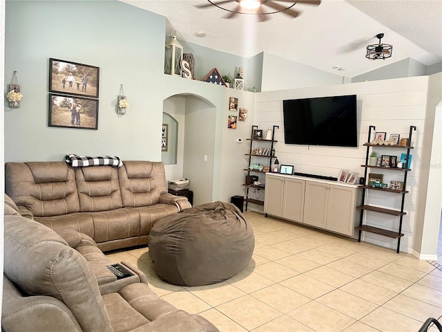 tiled living room featuring a textured ceiling, ceiling fan, and lofted ceiling