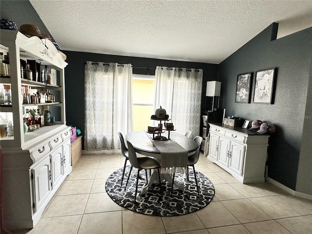 tiled dining space with lofted ceiling and a textured ceiling