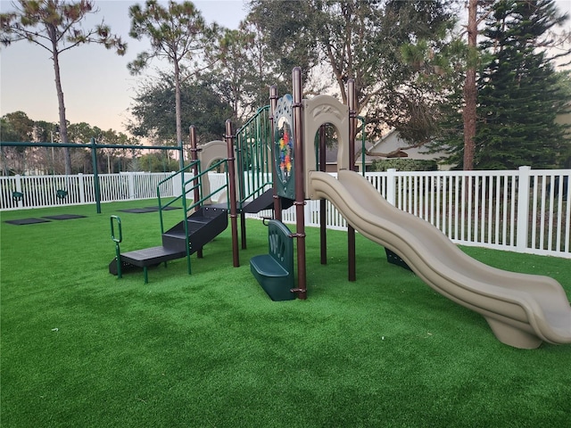 playground at dusk featuring a lawn