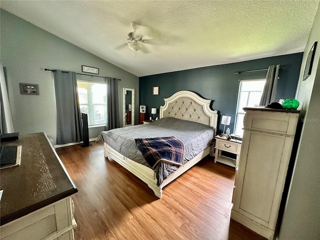 bedroom featuring a textured ceiling, hardwood / wood-style flooring, multiple windows, and ceiling fan