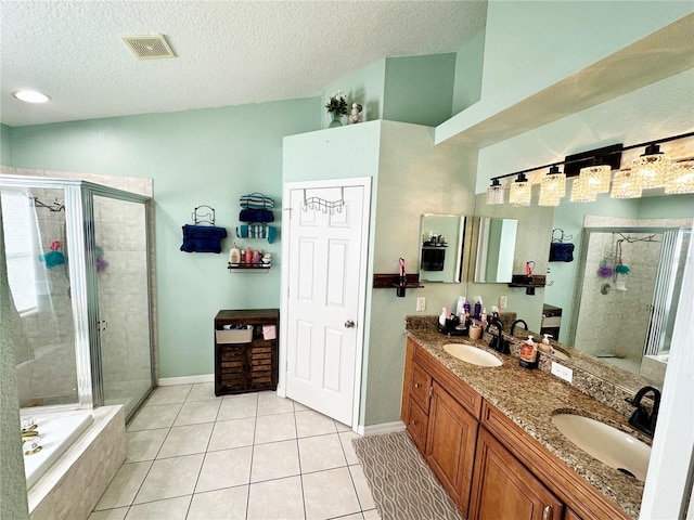 bathroom with vanity, a textured ceiling, separate shower and tub, and tile patterned floors