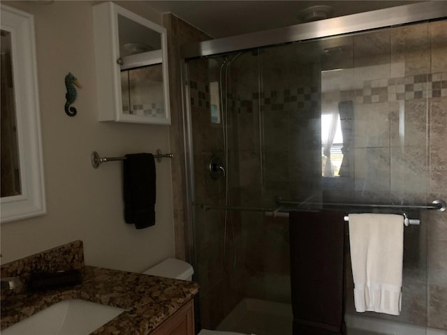 bathroom with vanity, toilet, and walk in shower