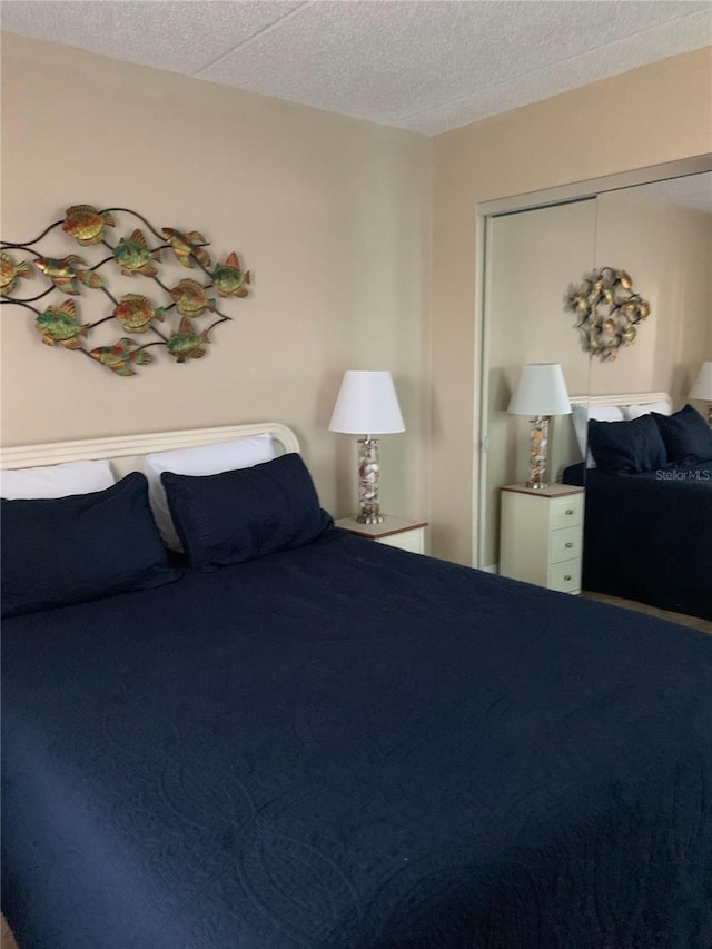 bedroom with a textured ceiling and a closet