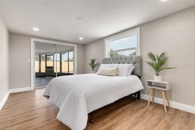 bedroom featuring access to exterior and hardwood / wood-style flooring