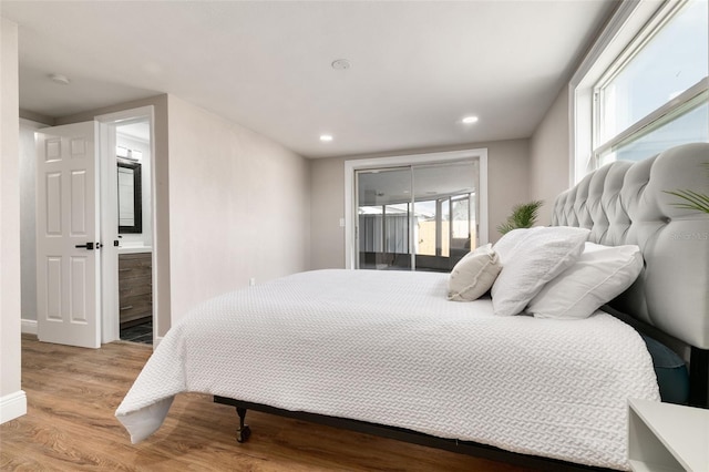 bedroom with access to outside, ensuite bathroom, light hardwood / wood-style flooring, and multiple windows