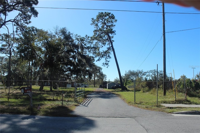 view of street featuring driveway, a gate, and a gated entry