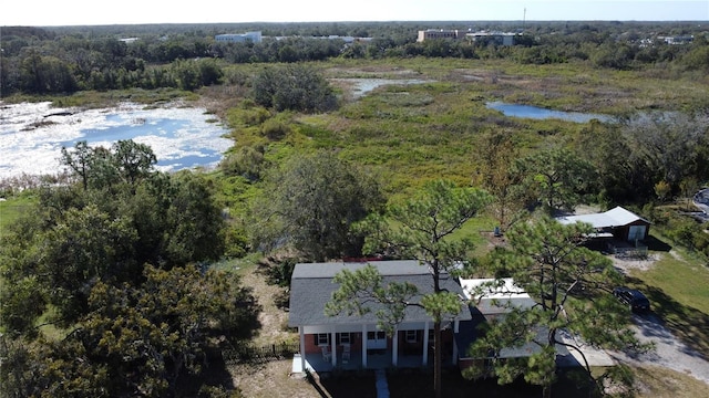 aerial view with a water view and a wooded view