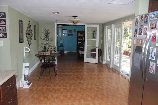 dining space with baseboards, visible vents, french doors, and light tile patterned flooring